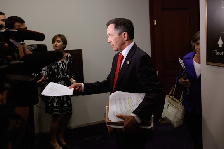 Dennis Kucinich hands out copies of a CBO report to reporters 