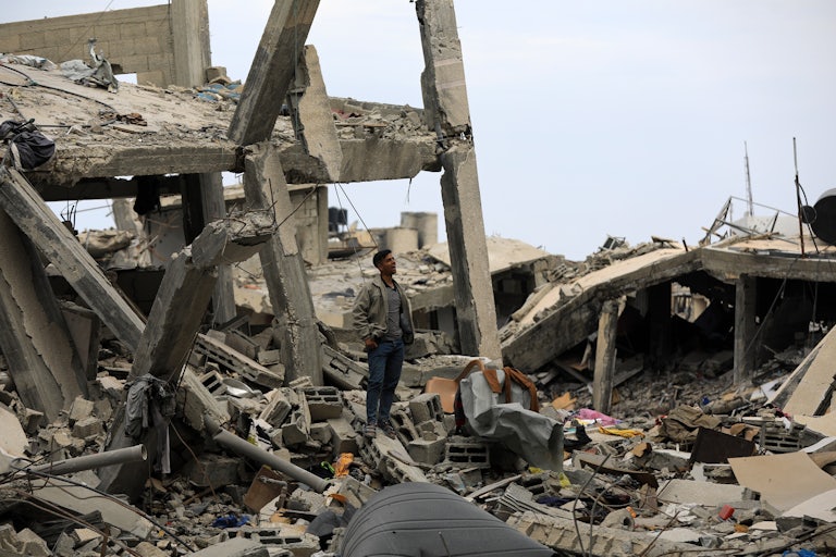 A Palestinian man stands amid rubble in Khan Younis