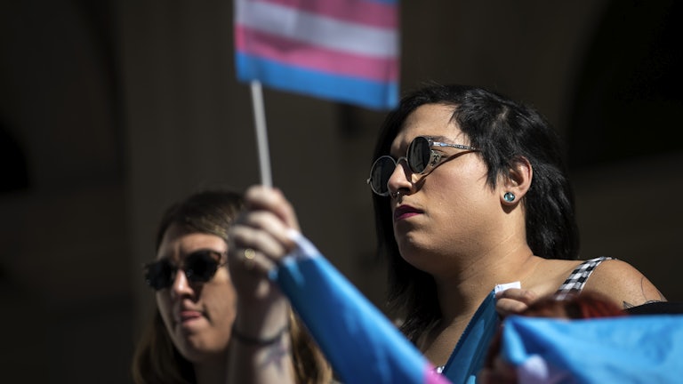 Activists and their supporters rally in support of trans people on the steps of New York's City Hall
