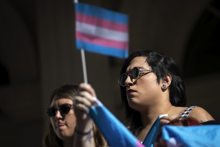 Activists and their supporters rally in support of trans people on the steps of New York's City Hall