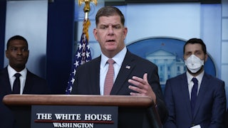 U.S. Labor Secretary Marty Walsh stands behind a lectern at the White House