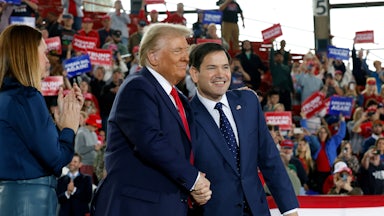 Donald Trump and Marco Rubio clasp hands at a rally.