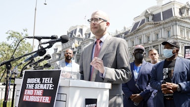 Eli Zupnick stands behind a lectern at a rally against the Senate filibuster.