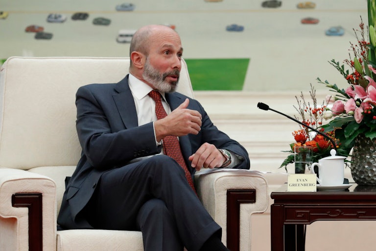 Evan Greenberg sits on a chair and is speaking