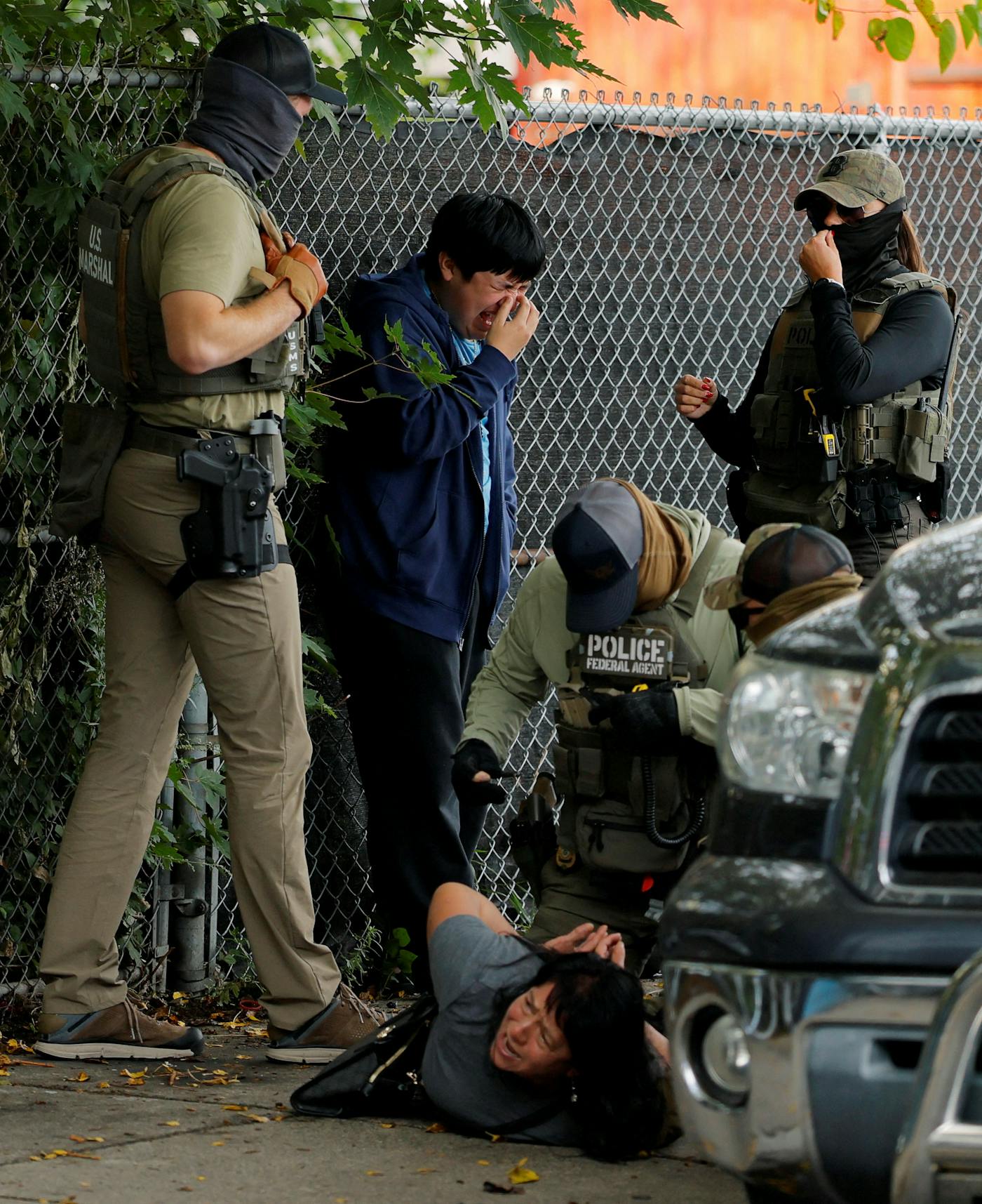 A photo from Chelsea, Massachusetts, showing masked federal agents detaining a woman on the ground in September as her son watched.