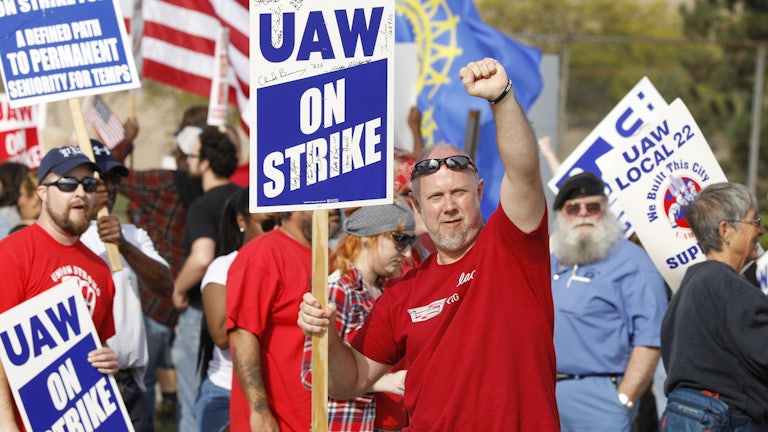 A United Auto Workers union member raises his fist on the picket line at the General Motors Flint Assembly plant.