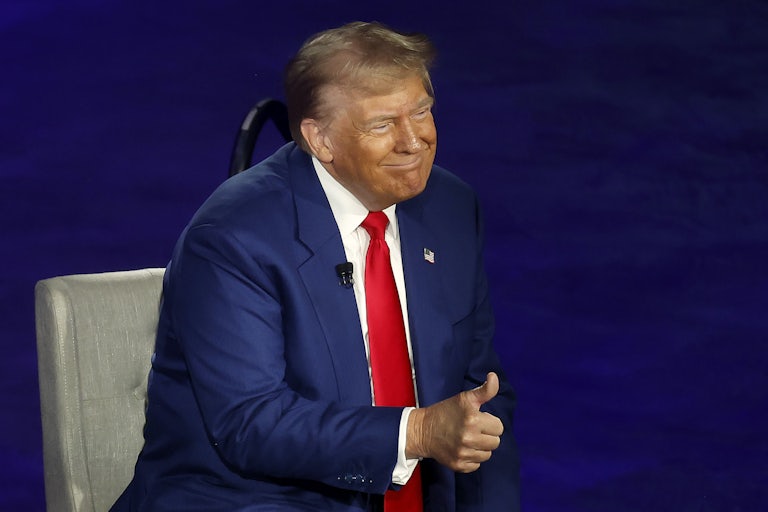 Donald Trump gives a thumbs-up while sitting onstage during his town hall with Sean Hannity