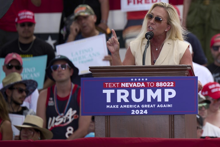 Marjorie Taylor Greene gestures as she speaks at a podium during a Trump rally