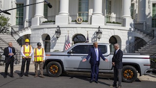 President Trump stands in front of an electric truck parked in front of the White House.