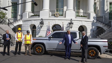 President Trump stands in front of an electric truck parked in front of the White House.