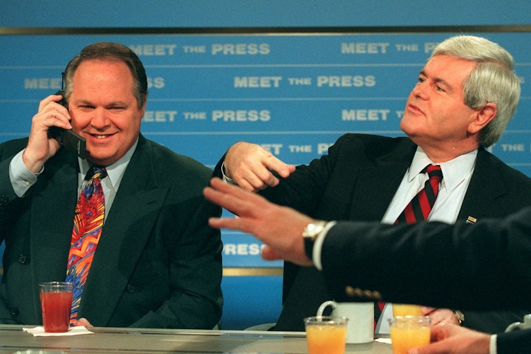 Radio talk show host Rush Limbaugh talks on a phone as House Speaker Newt Gingrich gestures during a break in taping of NBC’s “Meet the Press”