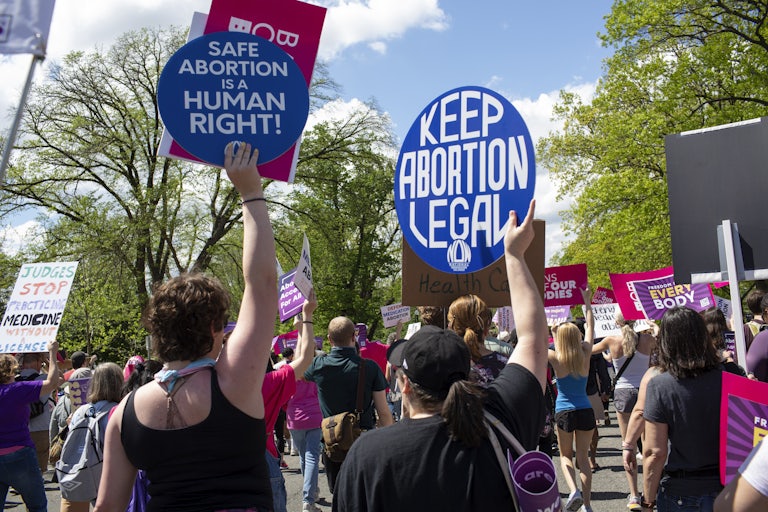 Activists holding abortion rights signs like "Safe abortion is a human right" and "Keep abortion legal."