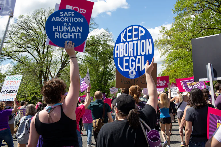 Activists holding abortion rights signs like "Safe abortion is a human right" and "Keep abortion legal."