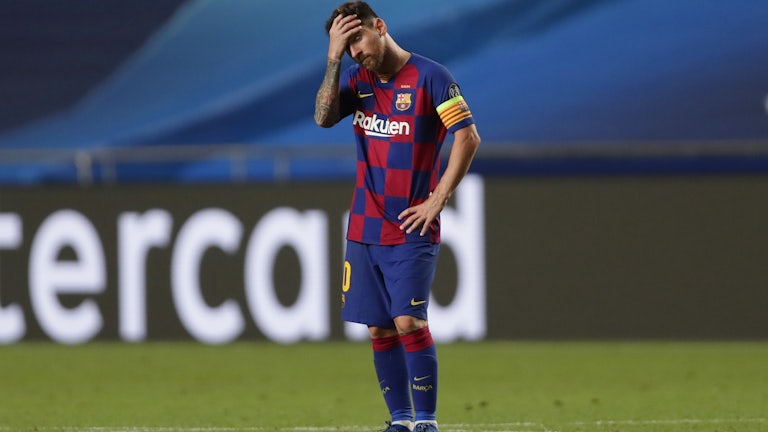 A dejected Lionel Messi holds his head in his hands after a match.
