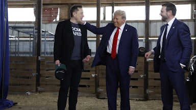 President Donald Trump visits with Elon Musk and JD Vance back stage during a campaign rally.