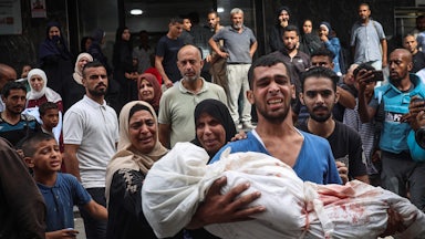 A Palestinian man carries the body of a relative killed at the Bureij refugee camp, in the central Gaza Strip on September 17, 2024,.