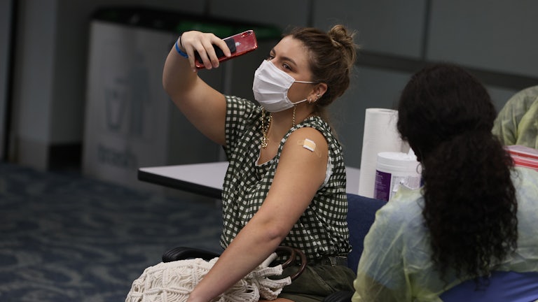 A woman takes a selfie after receiving a Covid shot.