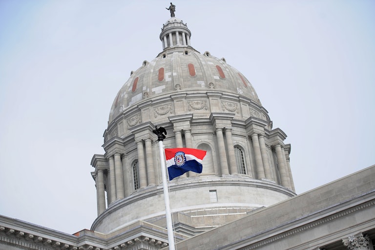 Missouri state Capitol building with Missouri flag