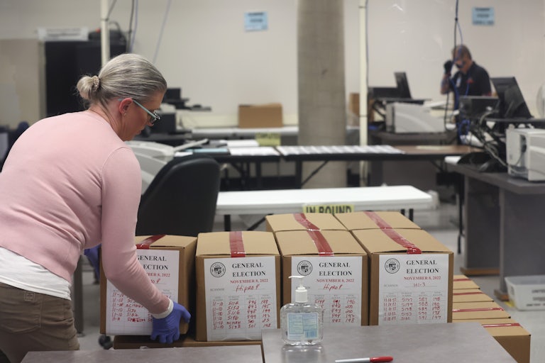 An election worker places a box of scanned ballots on a pallet at the Maricopa County Tabulation and Election Center in Phoenix, Arizona. 