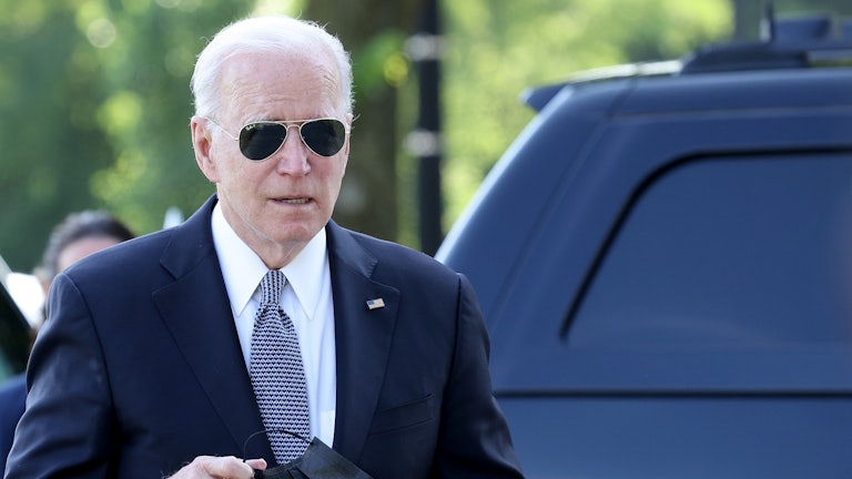 President Joe Biden removes his mask as he strolls to the White House.