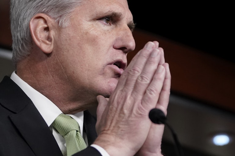 Kevin McCarthy puts his hands together in front of a podium.