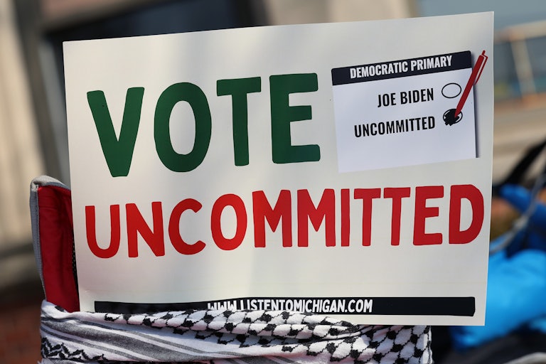 A campaign poster wrapped in a keffiyeh urges people to vote uncommitted instead of for Joe Biden