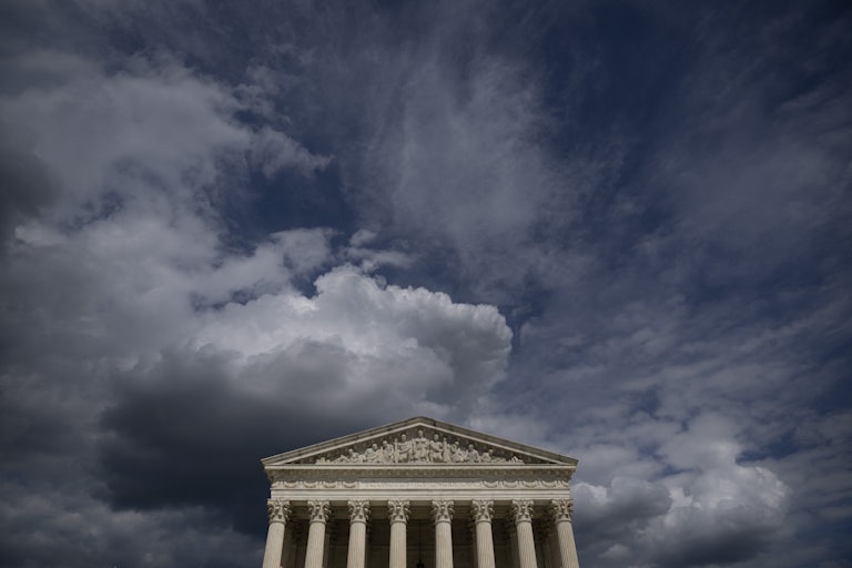 The facade of the Supreme Court appears below darkening skies.