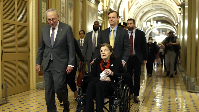 Senate Majority Leader Charles Schumer escorts Senator Dianne Feinstein