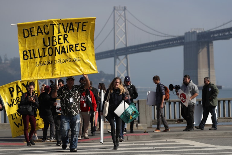Uber and Lyft drivers hold a sign reading “Deactivate Uber Billionaires” during a protest in San Francisco. 