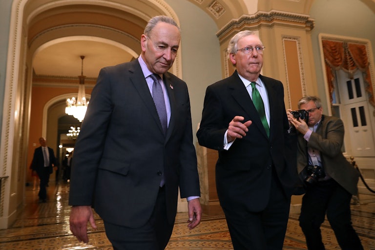 Senate Majority Leader Chuck Schumer and Senate Minority Leader Mitch McConnell stroll together through the halls of Capitol Hill