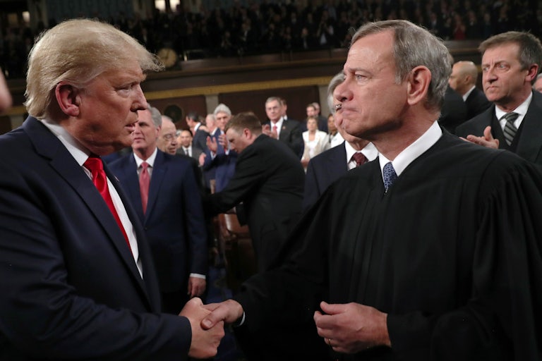 President Donald Trump shakes hands with Chief Justice John Roberts.