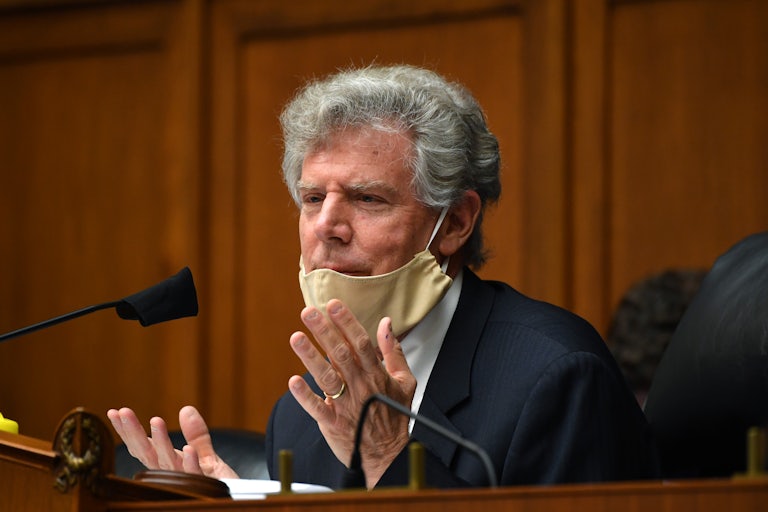 Frank Pallone speaks while seated, his face mask pulled down.