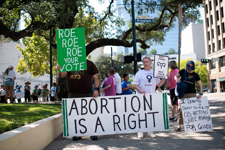 Demonstrators carry pro-choice signs.