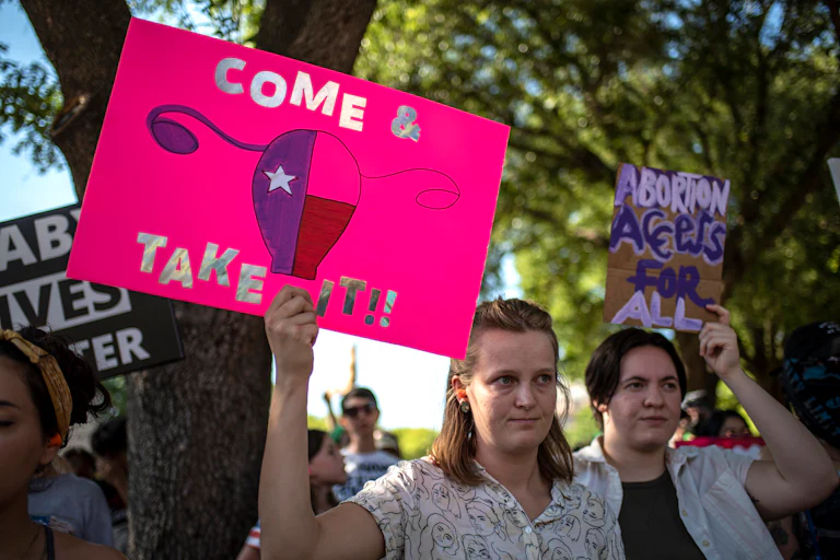 People hold up pro-abortion rights protest signs