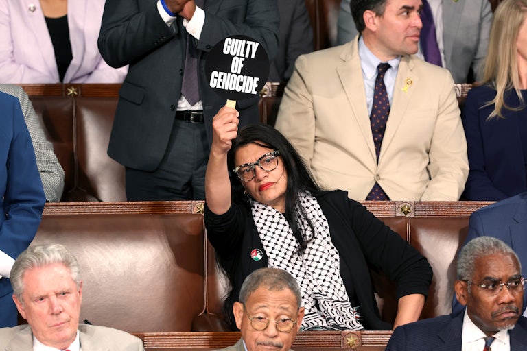 Rashida Tlaib holds a sign in the Capitol chamber that reads "Guiltly of Genocide"