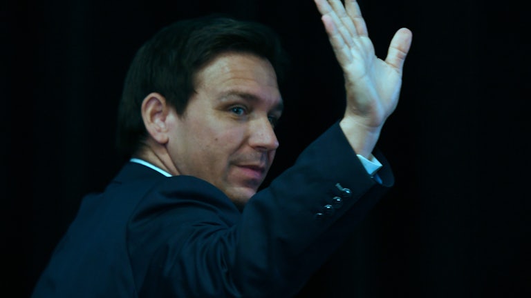 Florida Governor Ron DeSantis waves and looks over his shoulder