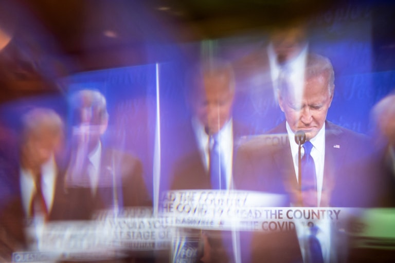 Former Vice President Joe Biden is seen on-screen through a window at a presidential debate watch party.