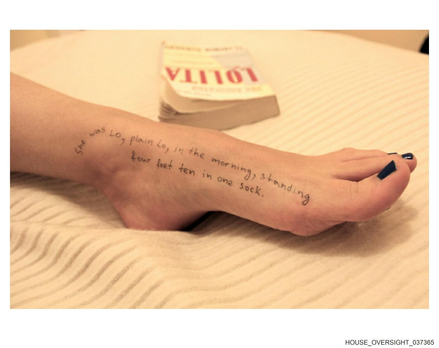"She was Lo, plain Lo, int he morning, standing four feet ten in one sock," written on a woman or girl's foot lying on a bed. In the background is the book Lolita.
