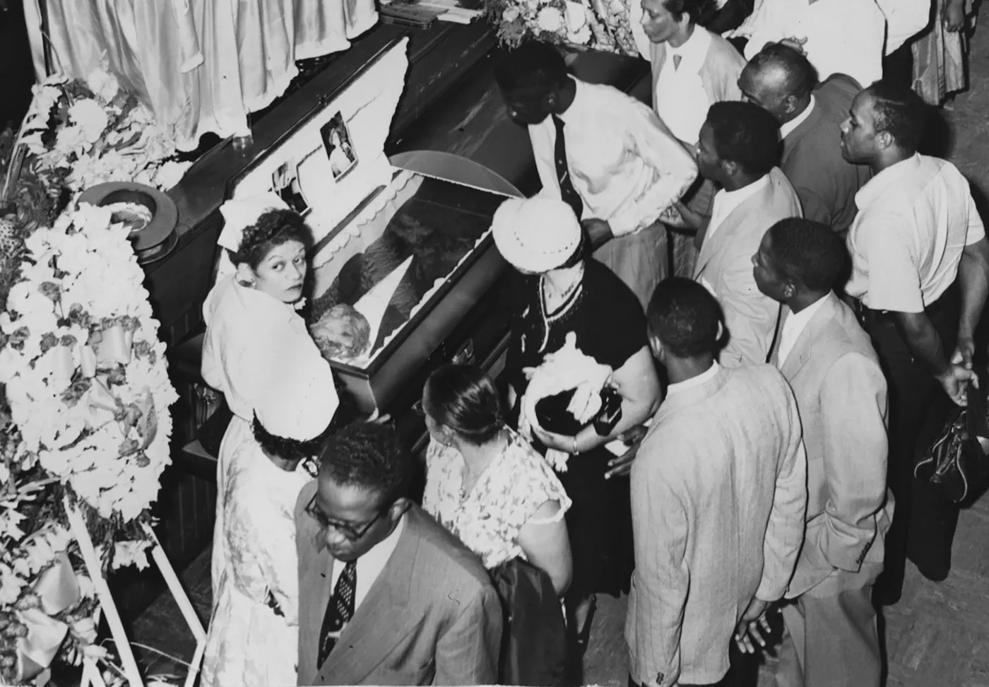 Mourners pay respects at the open casket of Emmett Till at his funeral in , with his mother standing by his head. Chicago, September 1955