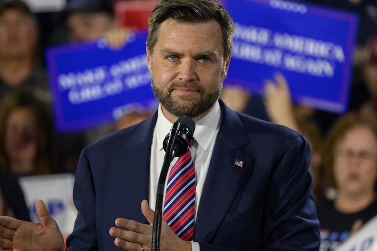 J.D. Vance gestures while on stage at a Donald Trump rally