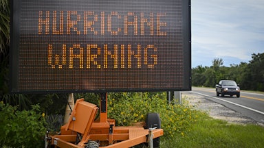A sign displays a hurricane warning along a roadside as preparations are made for the arrival of Hurricane Helene, in Cedar Key, Florida on September 25, 2024.
