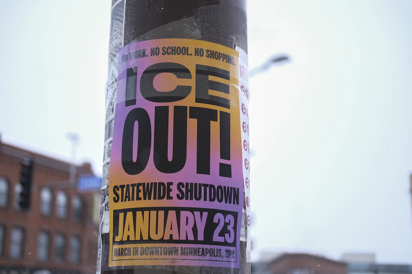 A pink poster taped on a pole that reads NO WORK NO SCHOOL NO SHOPPING ICE OUT STATEWIDE SHUTDOWN JANUARY 23rd MARCH IN DOWNTOWN MINNEAPOLIS 2pm