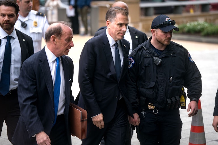 Hunter Biden walks while flanked by two men