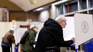 People lean over ballot desks.