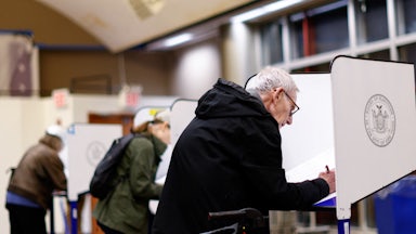 People lean over ballot desks.