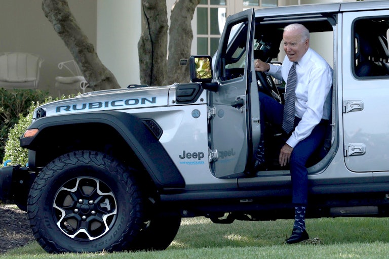 President Biden climbs out of a Jeep.
