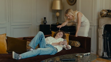 An episodic image from the movie Last Summer of a mature woman standing over a young boy