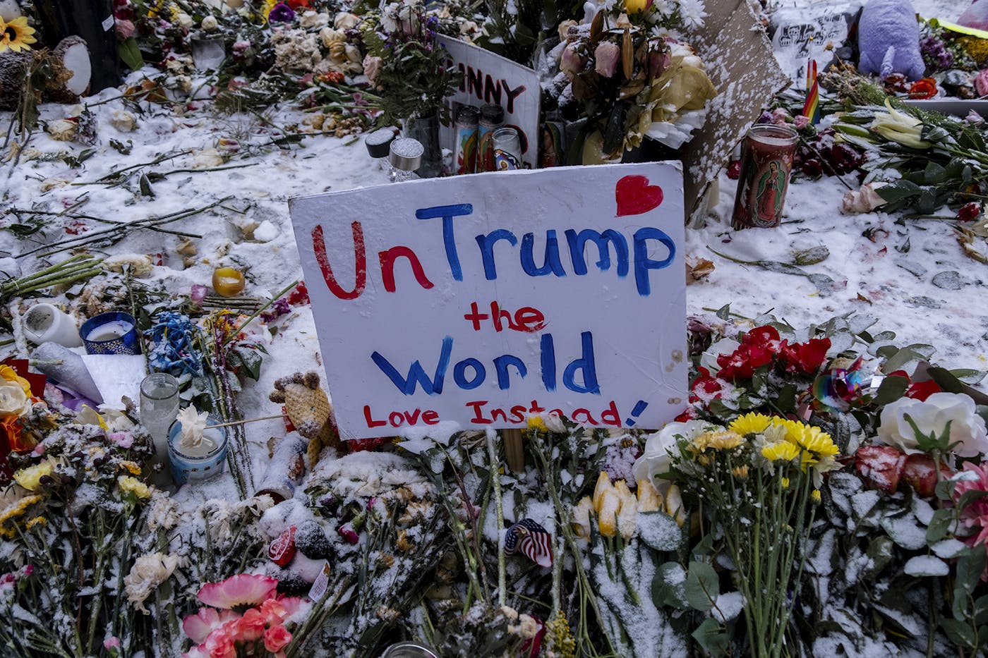 A homemade sign at Renee Good's memorial that reads UNTRUMP THE WORLD, LOVE INSTEAD!