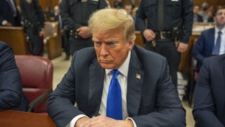 Donald Trump looks down while sitting in court for his hush-money trial