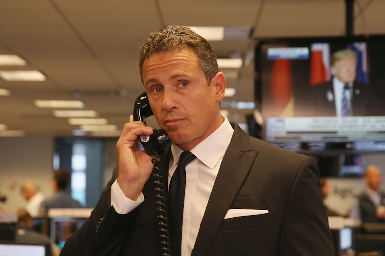 CNN anchor Chris Cuomo stands in an office making a telephone call.